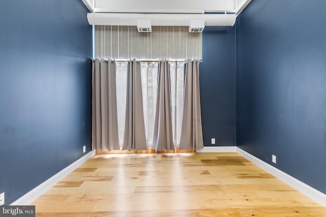 empty room featuring wood finished floors and baseboards