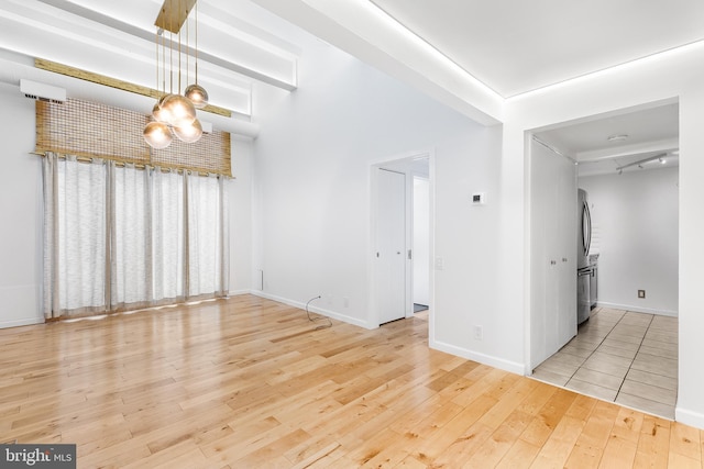 unfurnished living room featuring baseboards and wood finished floors