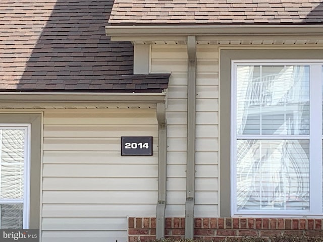 details with gutters, roof with shingles, and a downspout