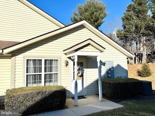 view of front facade with a shingled roof and cooling unit