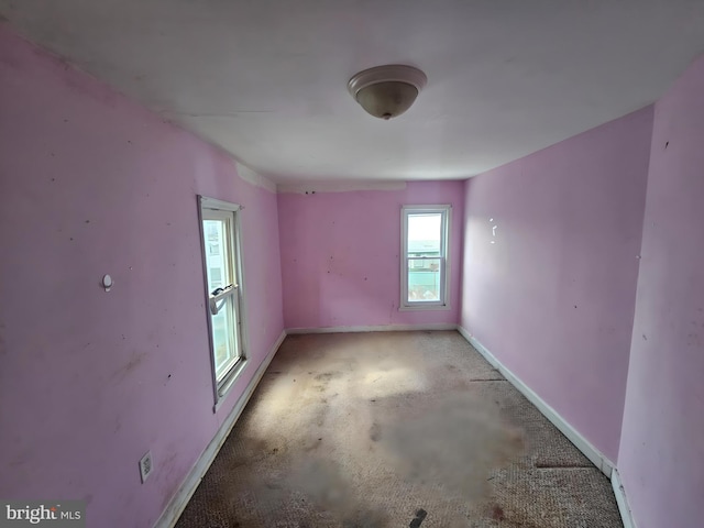 spare room with concrete floors and baseboards