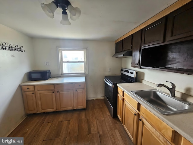 kitchen featuring black microwave, light countertops, a sink, and electric range