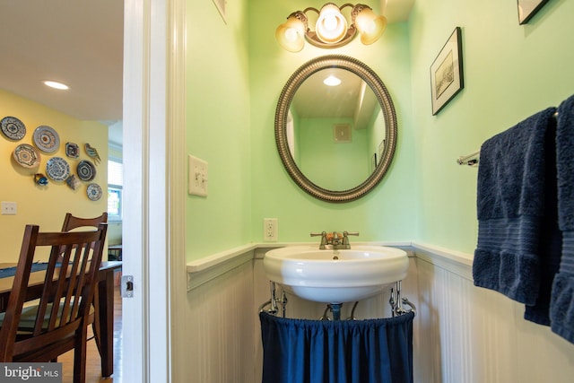 bathroom featuring recessed lighting, a sink, and wainscoting