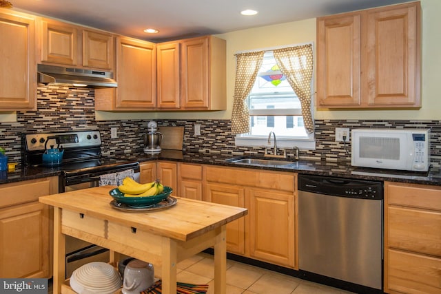 kitchen featuring white microwave, stainless steel dishwasher, under cabinet range hood, black range with electric cooktop, and a sink