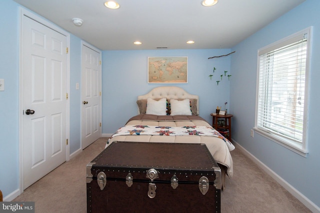 bedroom with recessed lighting, light colored carpet, visible vents, and baseboards