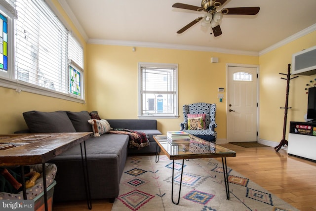 living area with ceiling fan, baseboards, crown molding, and wood finished floors