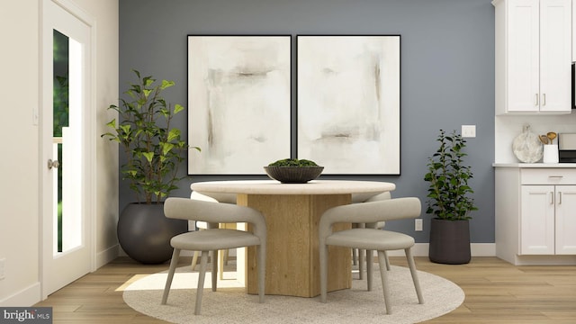 dining area featuring light wood-style floors and baseboards