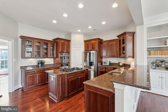 kitchen with dark wood-style floors, recessed lighting, appliances with stainless steel finishes, a sink, and a peninsula