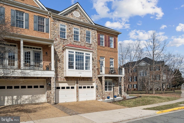 multi unit property featuring stone siding, brick siding, and an attached garage