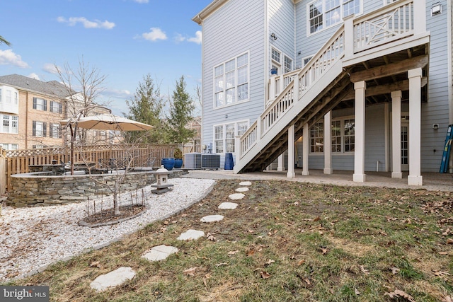 view of yard with central AC unit, a patio area, stairs, and fence