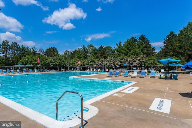 community pool featuring fence and a patio