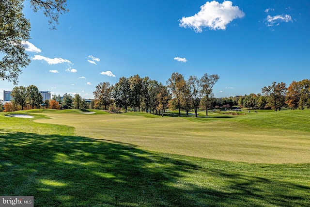 surrounding community with view of golf course and a yard