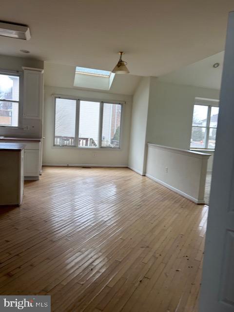 interior space featuring light wood-type flooring, a skylight, and a wealth of natural light