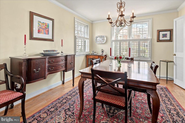 dining area with baseboards, ornamental molding, and wood finished floors