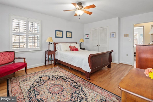 bedroom featuring a closet, light wood-type flooring, a ceiling fan, and baseboards