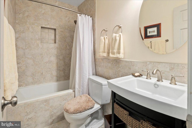 bathroom featuring tiled shower / bath combo, tile walls, toilet, and vanity