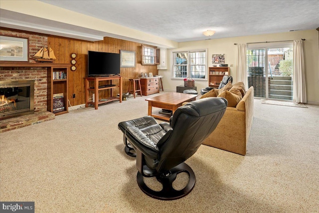 carpeted living room featuring wooden walls, a fireplace, and a healthy amount of sunlight