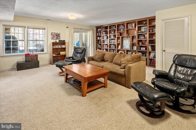 carpeted living area with baseboards