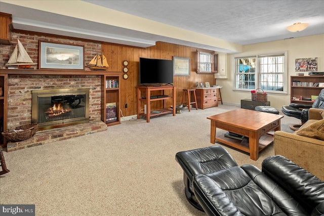 carpeted living area featuring wooden walls, a fireplace, and a textured ceiling