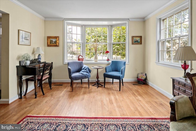 sitting room with ornamental molding, a healthy amount of sunlight, and wood finished floors