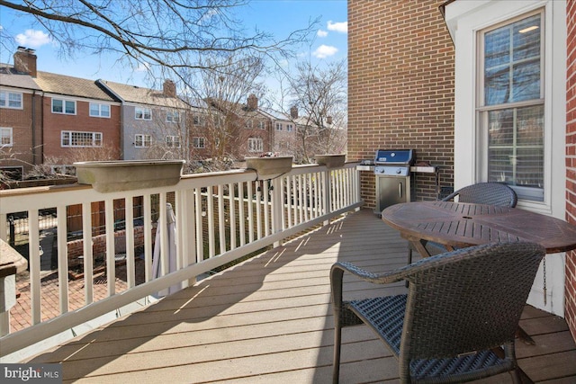 wooden terrace with a residential view and a grill