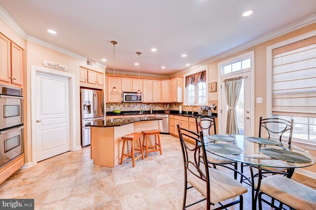 kitchen featuring stainless steel appliances, a kitchen island, ornamental molding, tasteful backsplash, and a kitchen bar