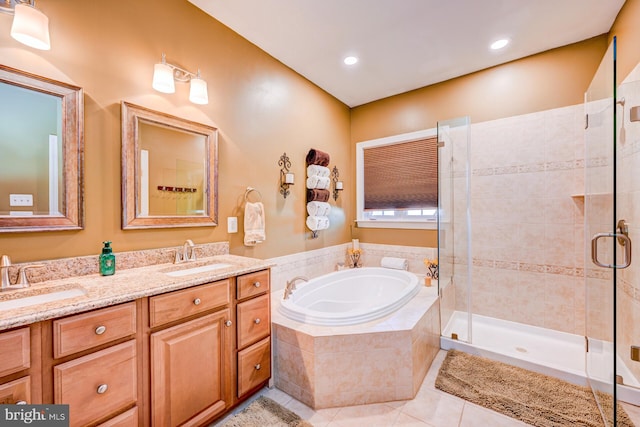 bathroom featuring a garden tub, a sink, a shower stall, and tile patterned floors