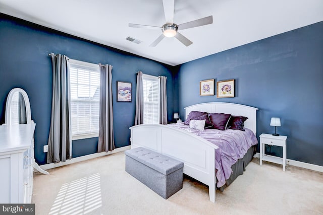 bedroom with light colored carpet, visible vents, ceiling fan, and baseboards