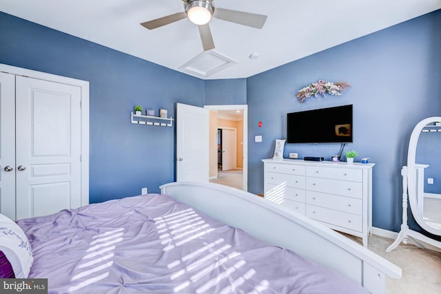 carpeted bedroom with ceiling fan, attic access, and baseboards