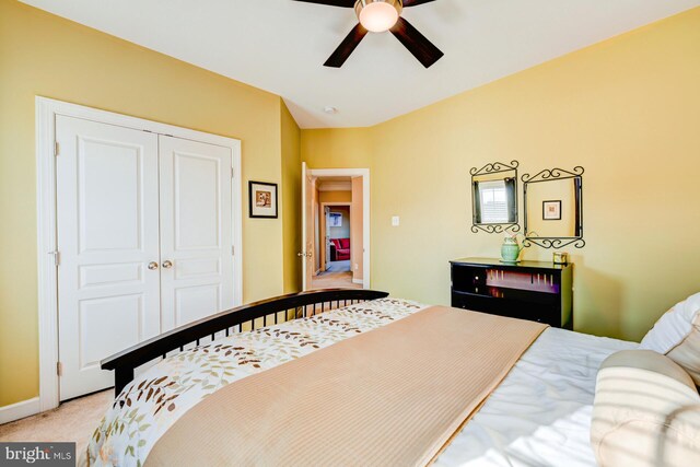 bedroom featuring ceiling fan, baseboards, a closet, and light colored carpet