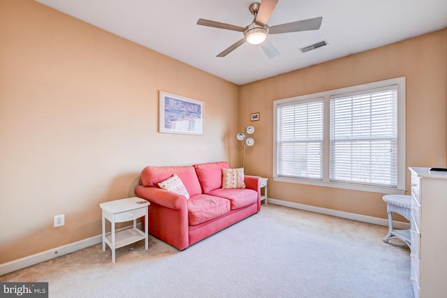 carpeted living room featuring baseboards, visible vents, and a ceiling fan