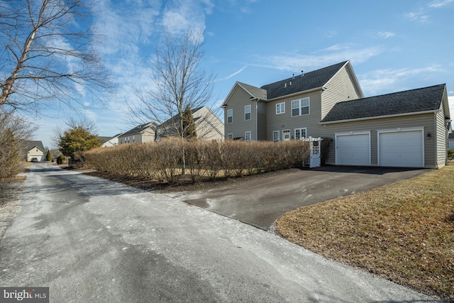 view of front of home featuring an attached garage and aphalt driveway