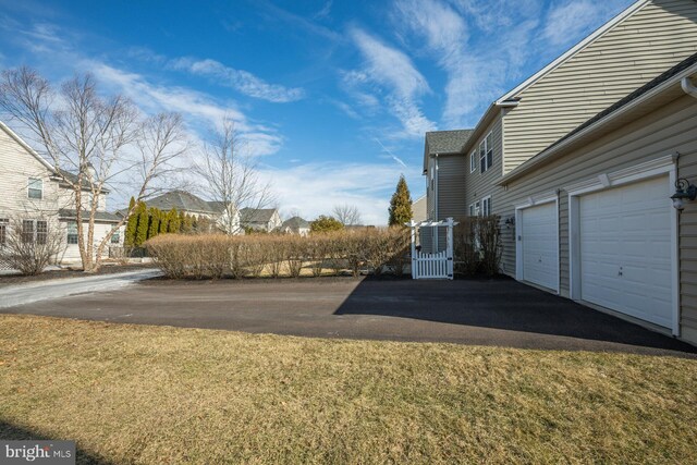 view of yard with a garage and driveway