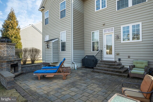 view of patio featuring entry steps and an outdoor stone fireplace