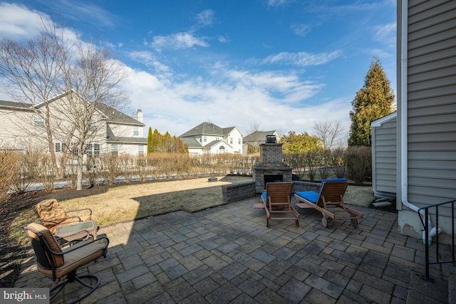 view of patio / terrace featuring exterior fireplace and fence