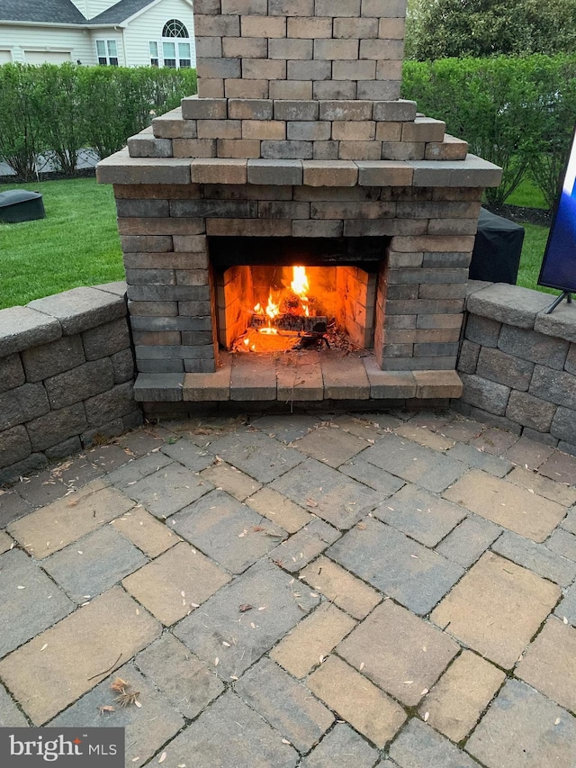 exterior details with driveway and an outdoor stone fireplace