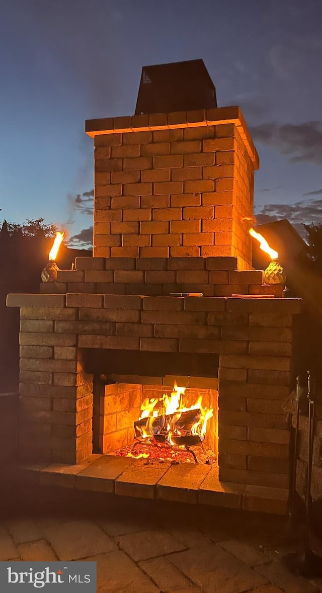 exterior details featuring a warm lit fireplace