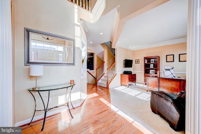 entryway with ornamental molding, stairway, baseboards, and wood finished floors