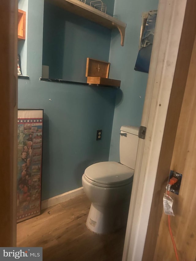 bathroom featuring toilet, baseboards, and wood finished floors