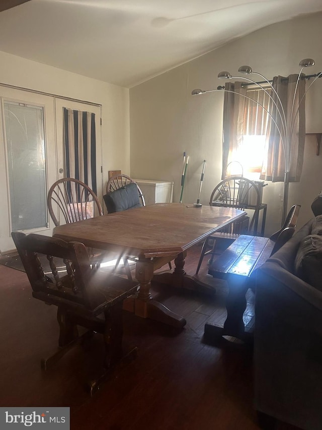 dining space featuring vaulted ceiling and wood finished floors