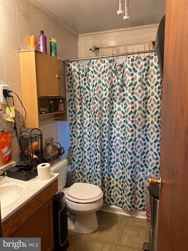 full bathroom featuring curtained shower, toilet, vanity, tile walls, and ornamental molding