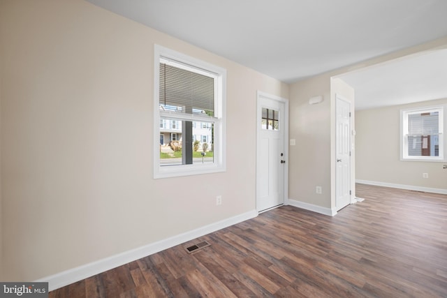 interior space featuring dark wood finished floors, visible vents, and baseboards