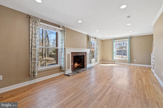 unfurnished living room with a fireplace, hardwood / wood-style floors, baseboards, and ornamental molding