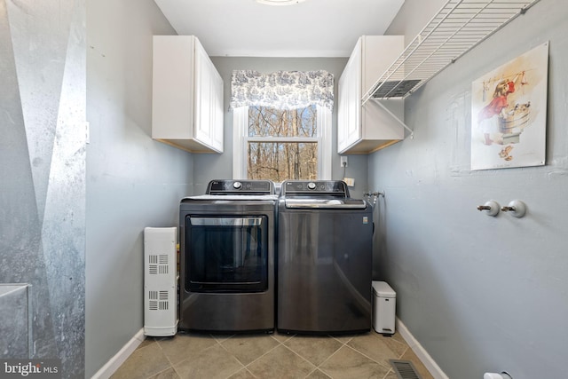 clothes washing area with separate washer and dryer, light tile patterned floors, cabinet space, and visible vents