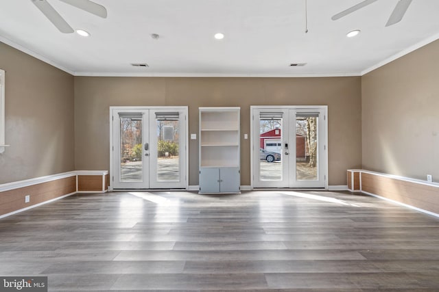 unfurnished room featuring french doors, crown molding, and wood finished floors