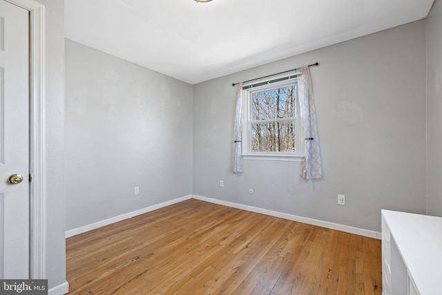 empty room with baseboards and light wood-style floors