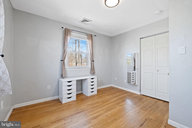 unfurnished bedroom with visible vents, baseboards, a closet, and light wood-style flooring