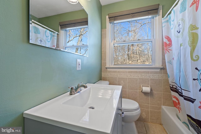 bathroom with tile patterned flooring, tile walls, toilet, and vanity