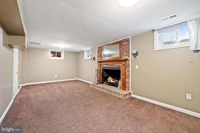 unfurnished living room featuring carpet flooring, a brick fireplace, baseboards, and visible vents