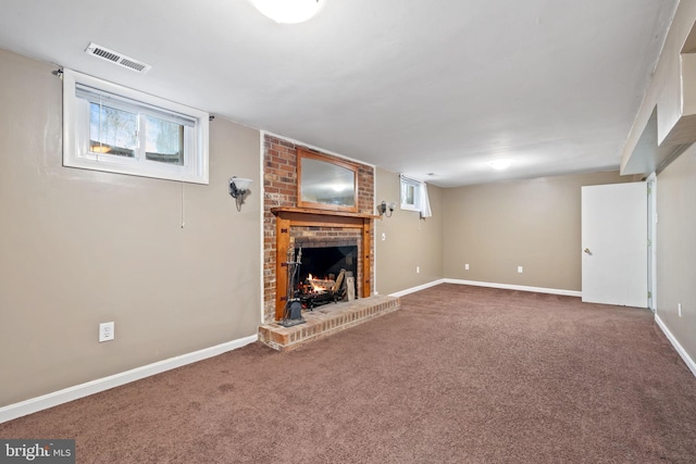 unfurnished living room featuring visible vents, baseboards, carpet, and a fireplace